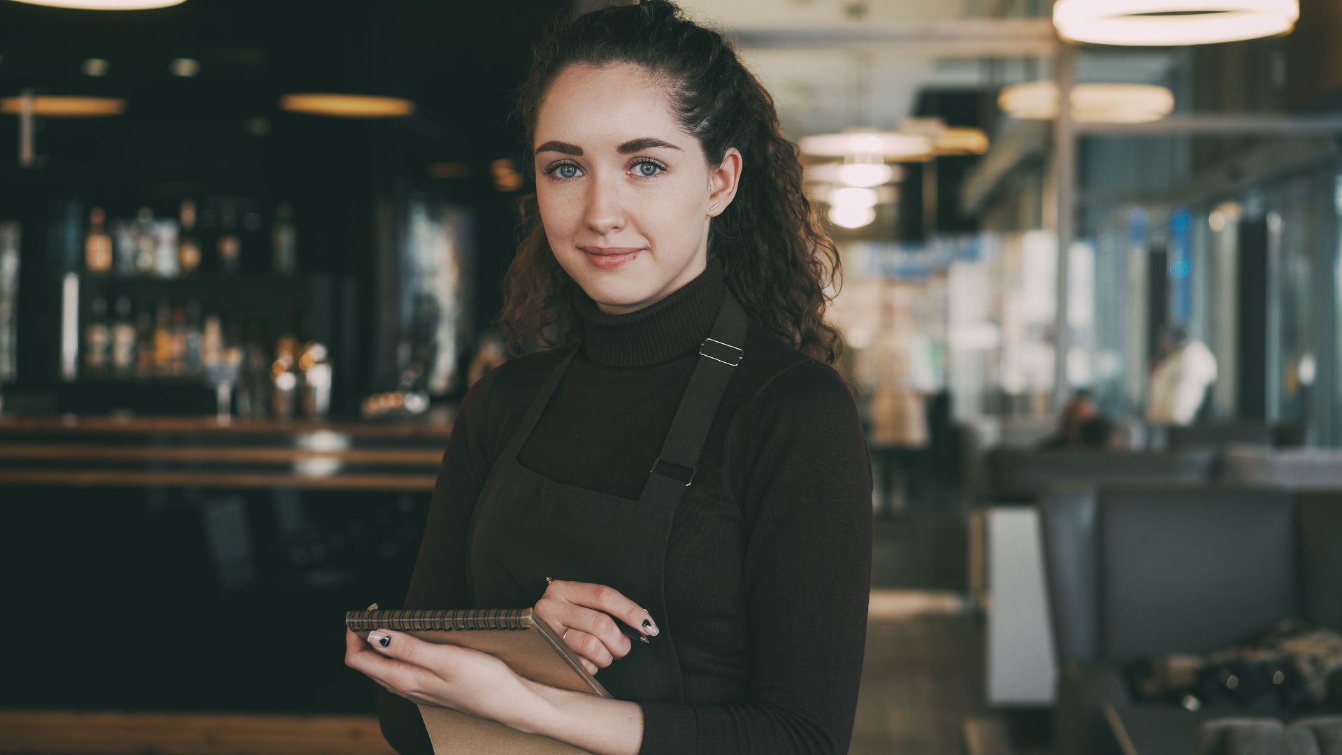Waitress serving customers in a busy Bedfordshire café
