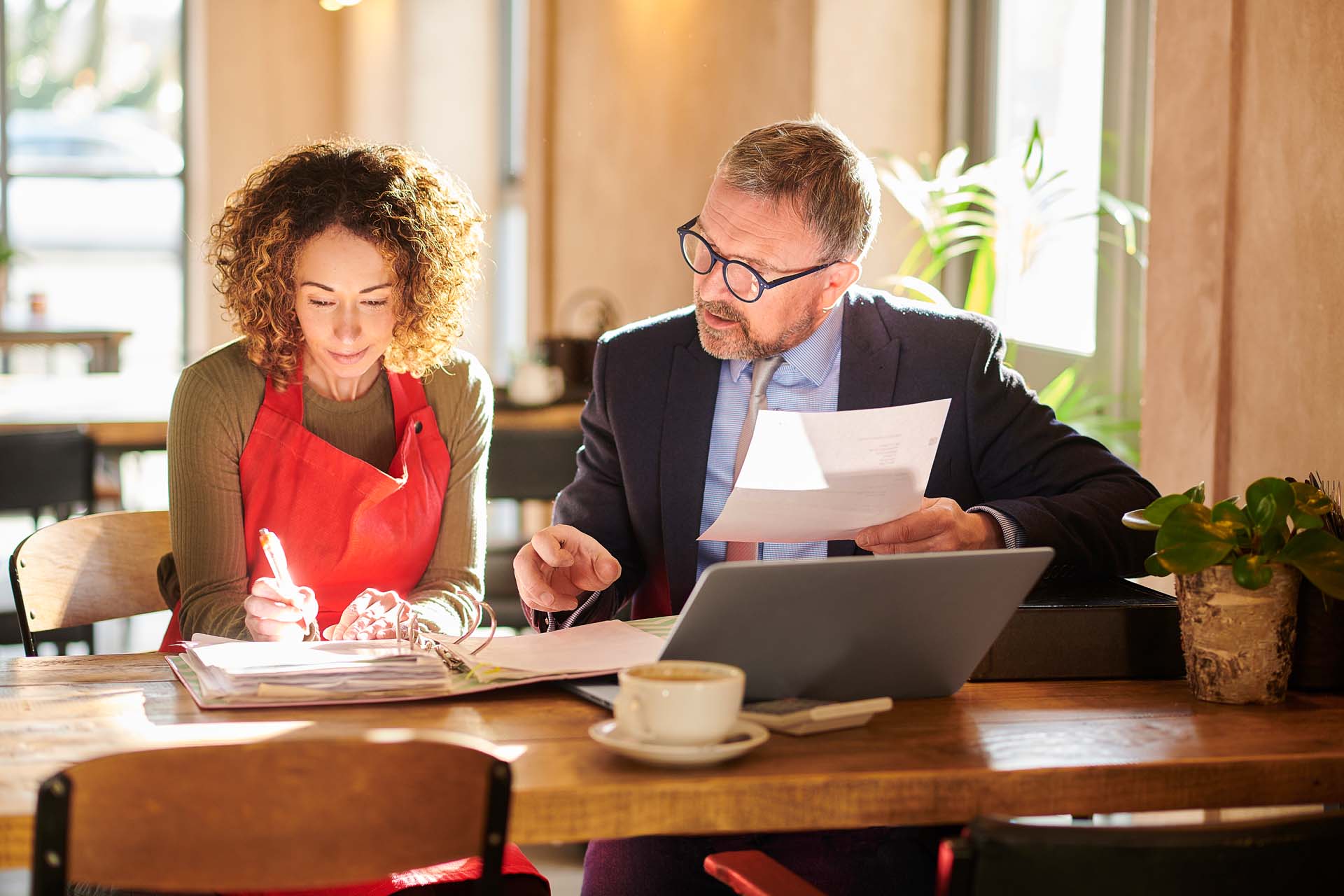 A café owner and financial advisor reviewing accounts together