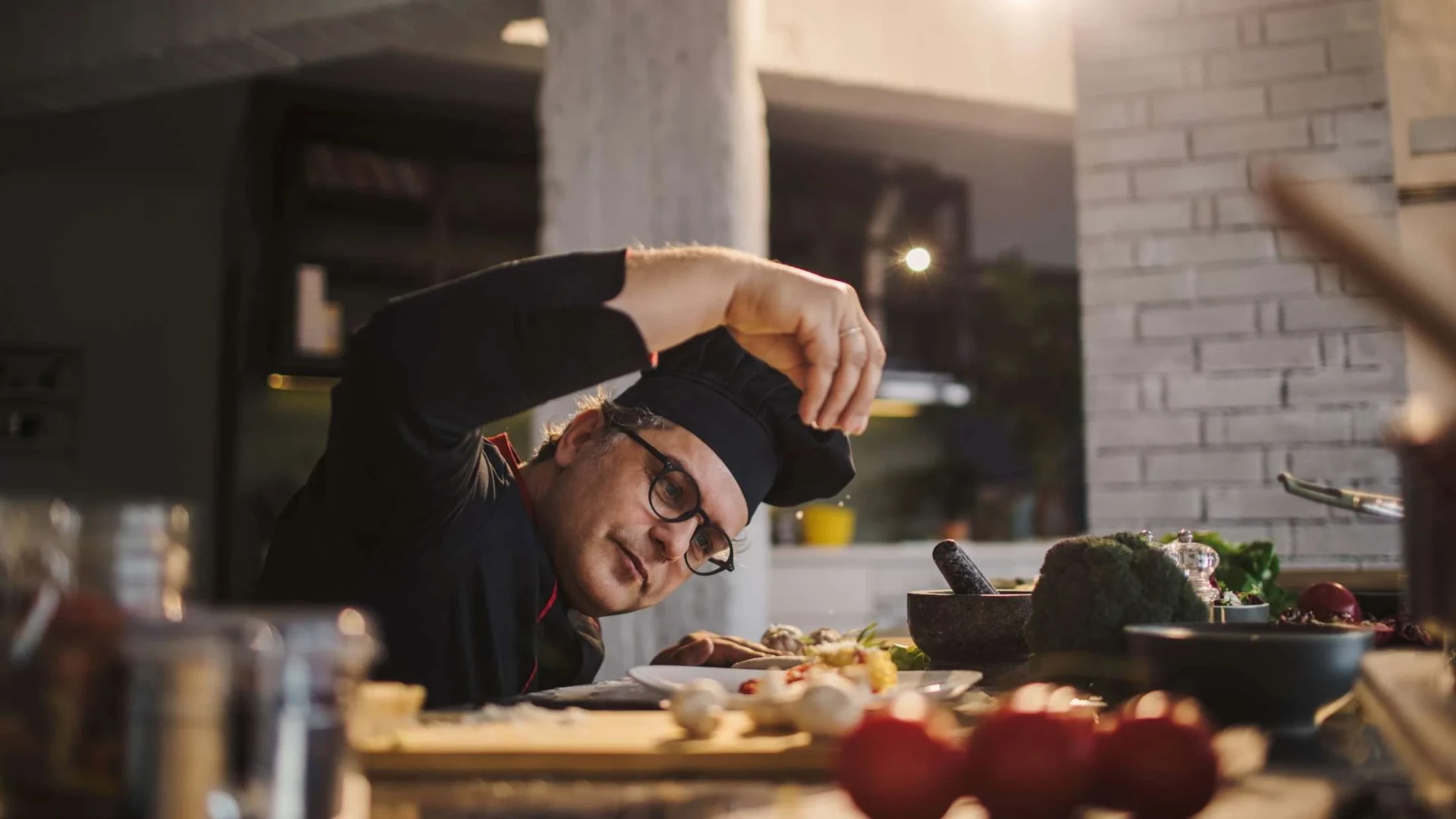Bedfordshire chef seasoning a dish in a professional kitchen